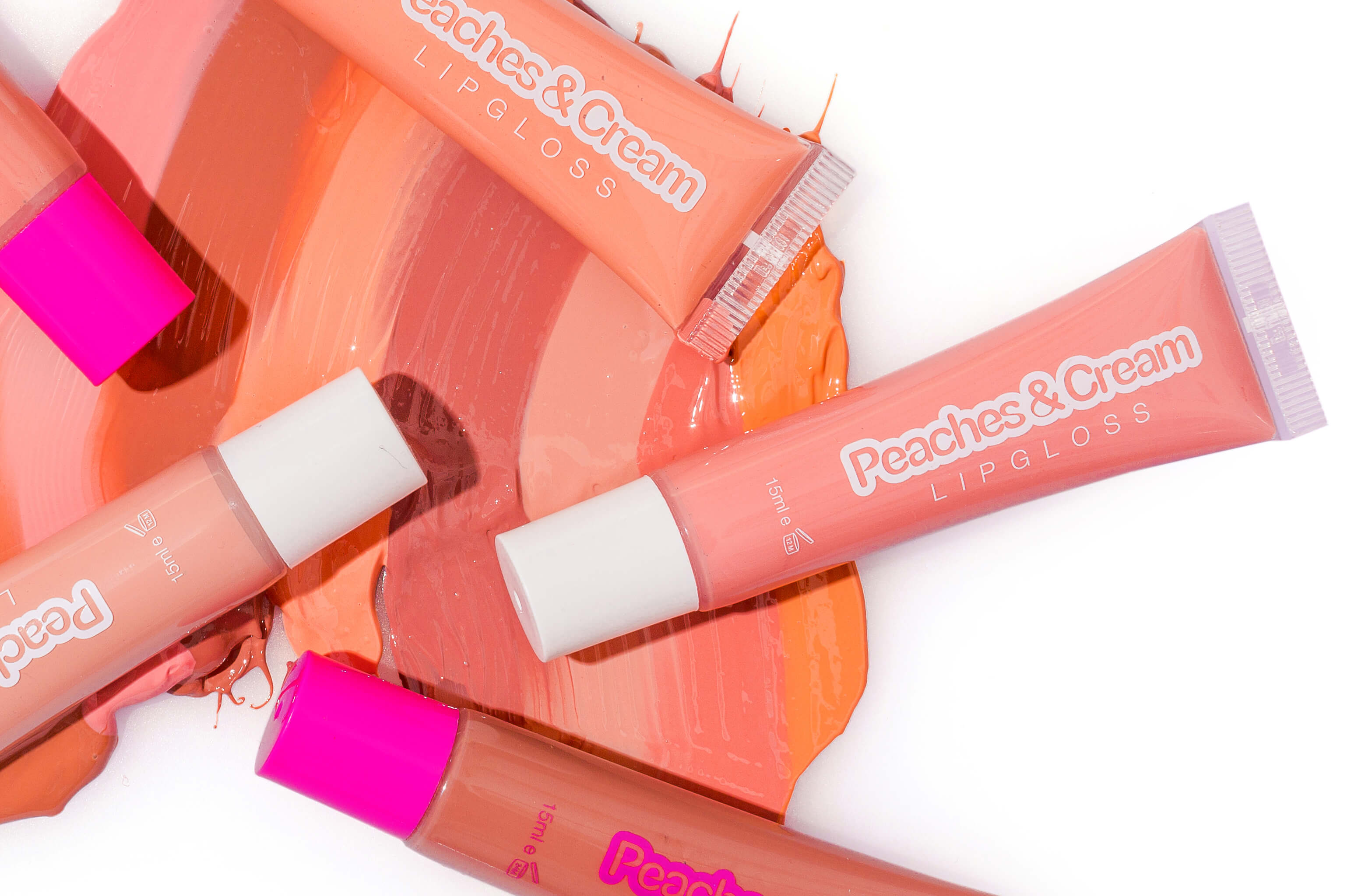 Swatches of Peaches & Cream Lip Glosses with 4 Peaches & Cream lip gloss tubes