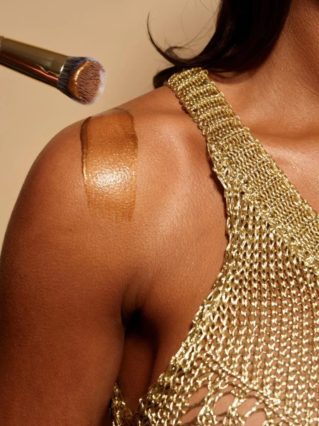 body glaze body shimmer by peaches and cream shown being brushed onto models shoulder by a gold pc21 brush