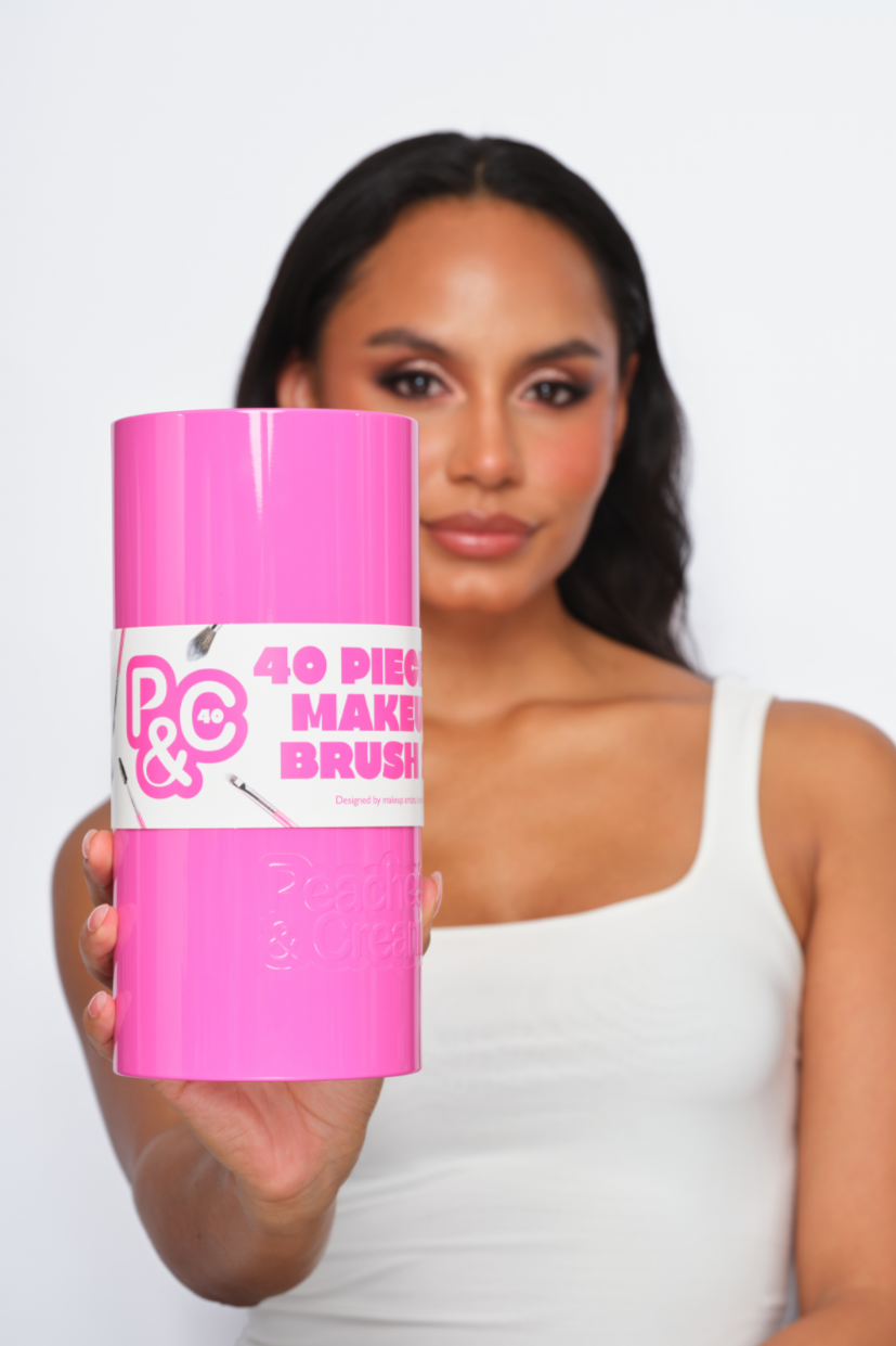 Woman holding a pink makeup brush container