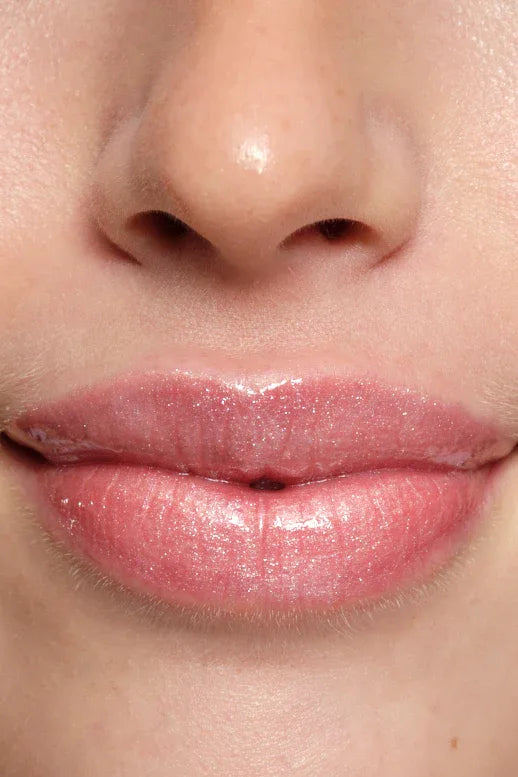 Close-up of a person's lips with a glossy pink lipstick in shade bubble from Peaches & Cream