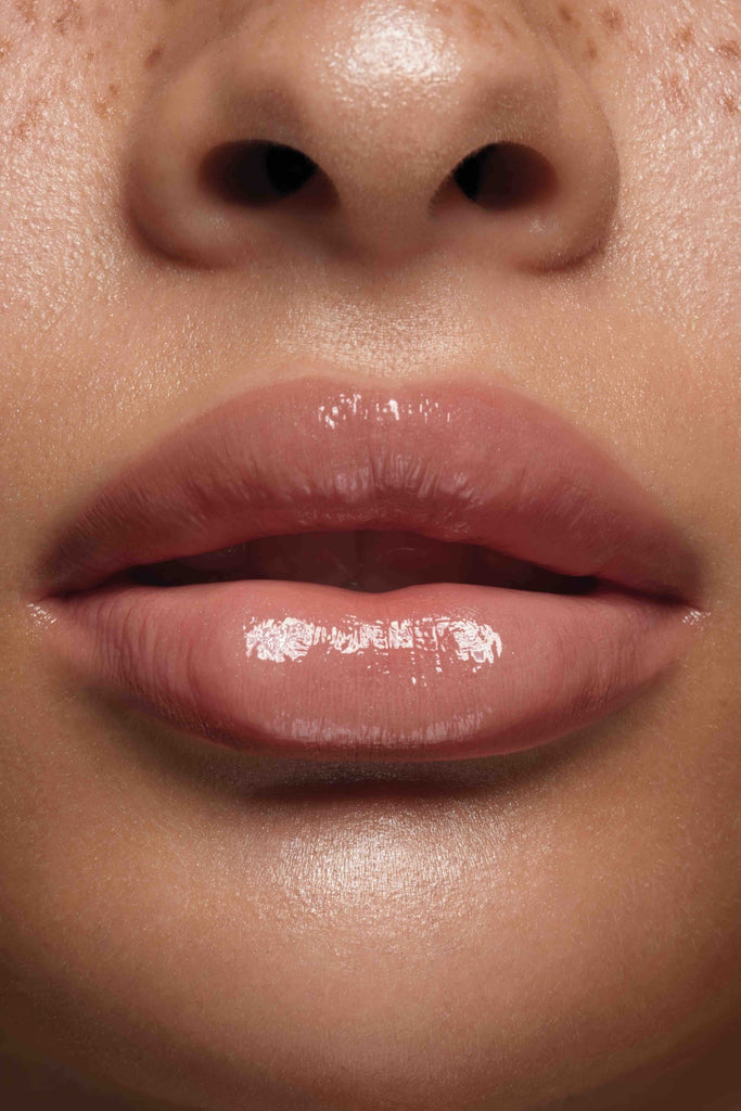 Bare lip gloss shown on model's lips