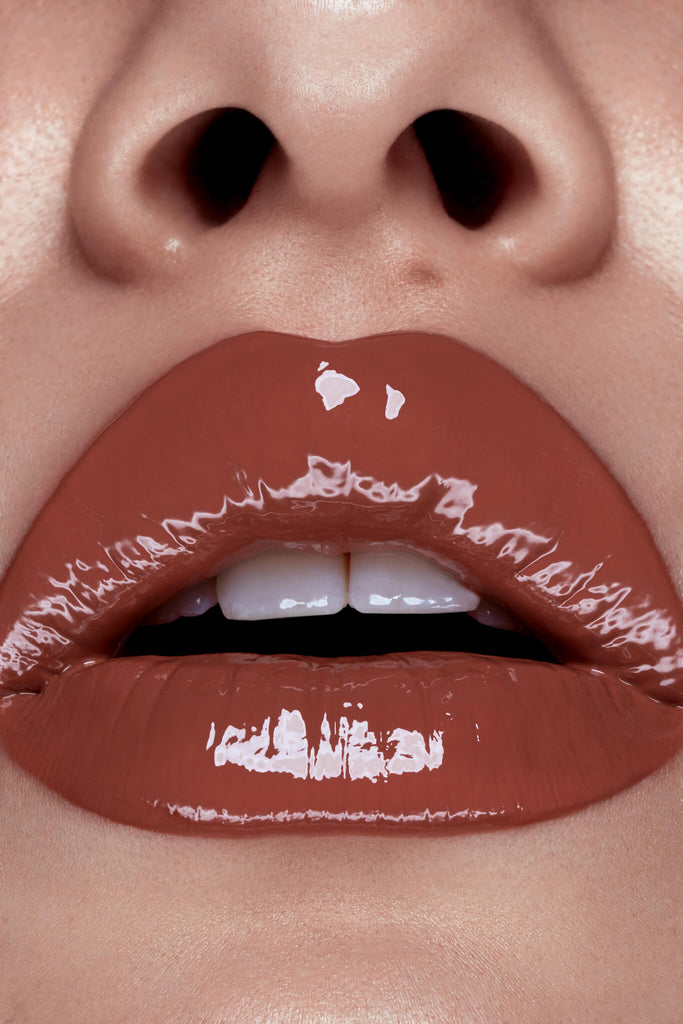 Rusted lip gloss shown on model's lips