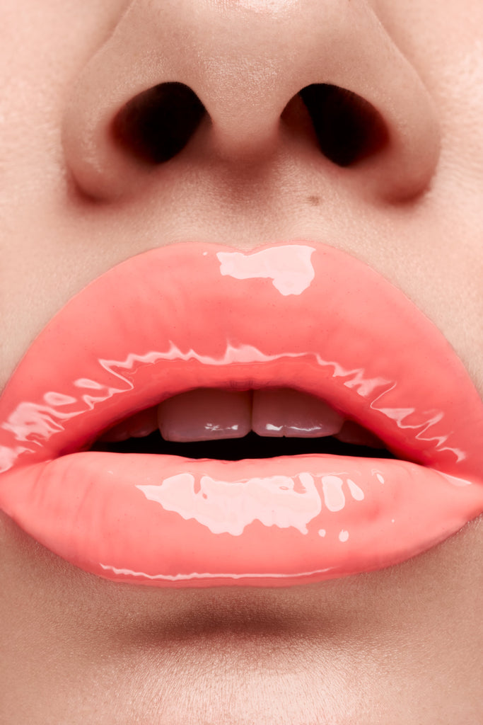 Flamingo lip gloss shown on model's lips